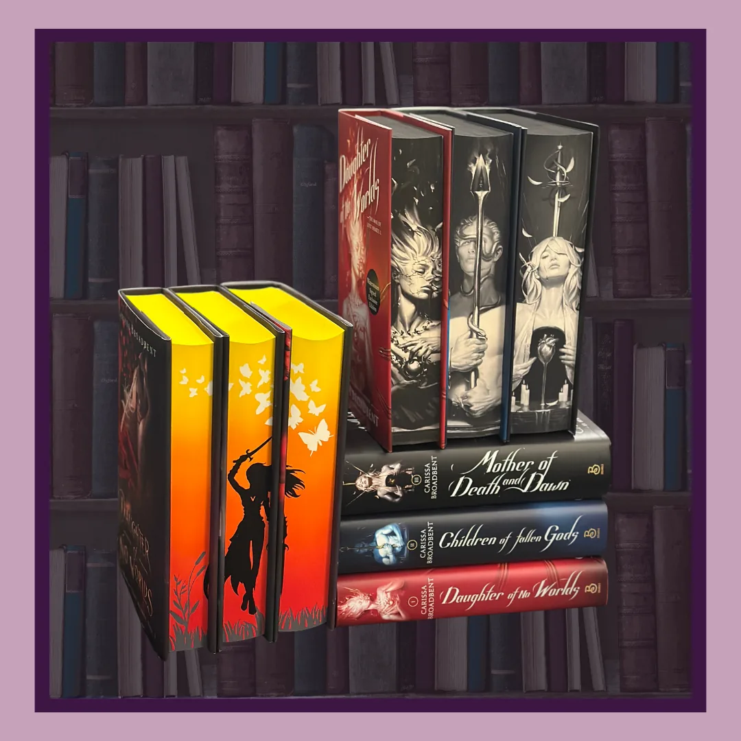 The War of Lost Hearts by Carissa Broadbent, three sets on a shelf. Three hardcovers with painted orange and yellow page edges, three standing with black and white illustrated edges, and three stacked with the titles on their spines.